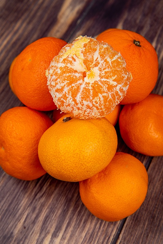 side view of fresh ripe tangerines on rustic wooden background