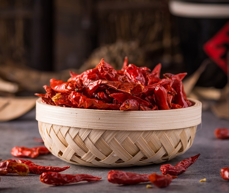 various dried fruits in a bowl on a trivet , on the marble background