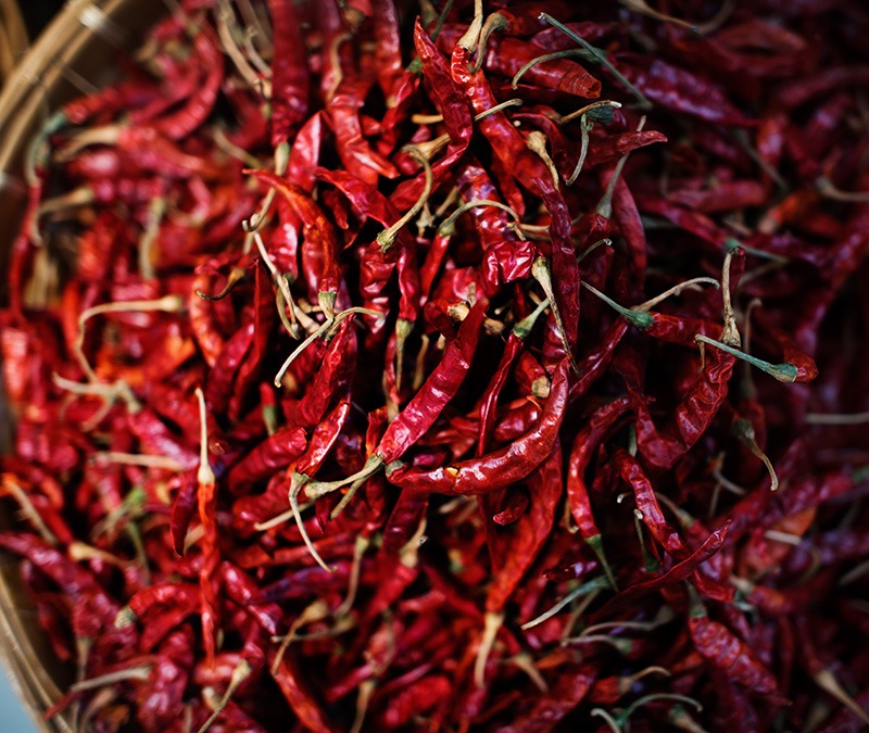 various dried fruits in a bowl on a trivet , on the marble background
