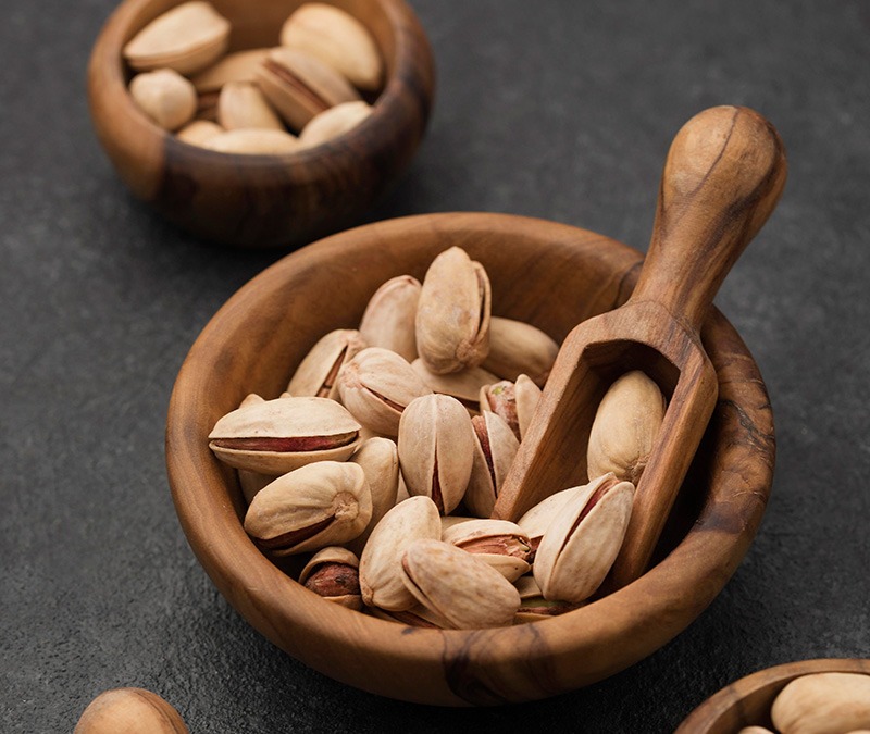 various dried fruits in a bowl on a trivet , on the marble background
